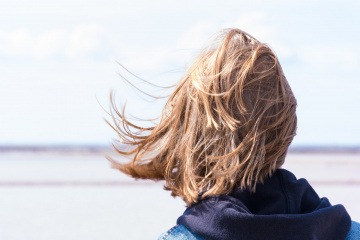 Eine Frau von hinten versucht, ihre Seele zu hören