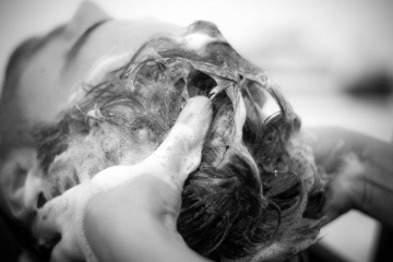 Einem Mann werden die Haare mit Shampoo gewaschen