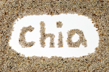 Chia-Samen sind auf einer Oberfläche verstreut und aus ihnen ist in der Mitte der Name "Chia" geformt worden