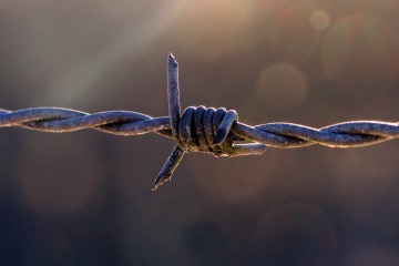 Ein Stacheldraht ist als Symbol für eine Abgrenzung zu sehen