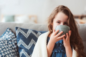 Kind trinkt Tee gegen Übelkeit