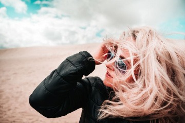 Frau mit Winterjacke und trockener Haut im Wind