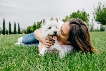 Frau mit Hund auf einer Wiese