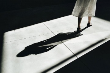 Eine Frau geht vor ihrem Schatten weg