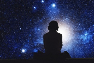 Was ist Karma? Eine knifflige Frage, doch vielleicht kommt man leichter auf eine Antwort, wenn man, wie die Person in diesem Bild, im Dunkeln sitzt und in den klaren Sternenhimmel blickt.