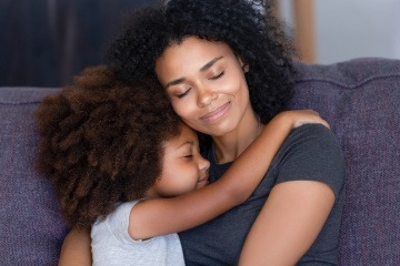 kleines Mädchen kuschelt mit der Mutter