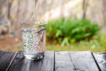 Lebendig wirkendes Wasser fließt in ein Glas