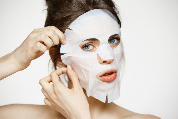 Frau mit Tuchmaske im Gesicht