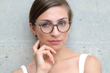 Selbstbewusste Frau mit runder Brille