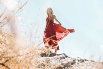 Eine Frau auf einem Felsen strahlt Würde aus