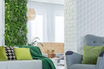 Ein Zimmer ist in Möbeln mit Grüntönen eingerichtet