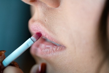 Eine Frau trägt einen Lippenstift auf