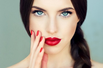 Eine Frau hat blaue Augen und rote Lippen