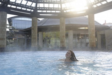 Eine Frau schwimmt im Thermenbereich des Parkhotel Kurhaus